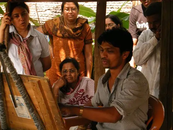 Shri. Sandeep Yadav explaining painting details to participants and pariticipants viewing painting demonstration