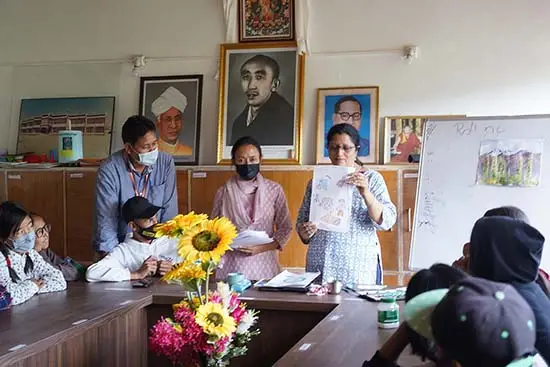 Chitra Vaidya showing paintings to children