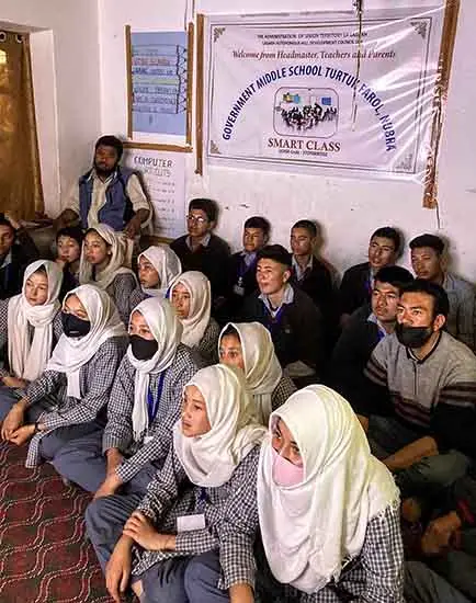 boys and girls watching the digital display of artworks at their school at Turtuk Baltistan in Ladakh