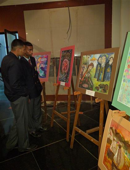 Cadets of National Defence Academy looking at paintings by Russian children