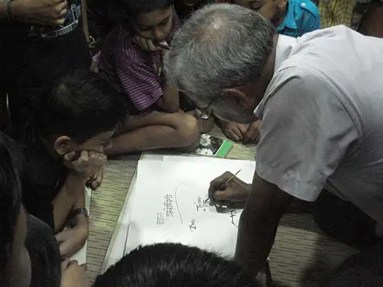 Prof. Babu Udupi demonstrating Devanagari calligraphy 