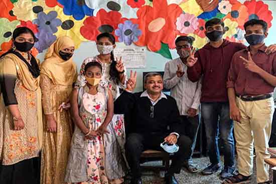 students of Indian Red Cross Society’s School for Deaf, Pune along with their art teacher in front of their collective artwork