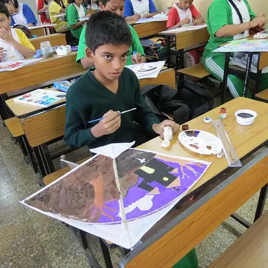 Boy from Madhavrao Bhagwat High School painting a kite