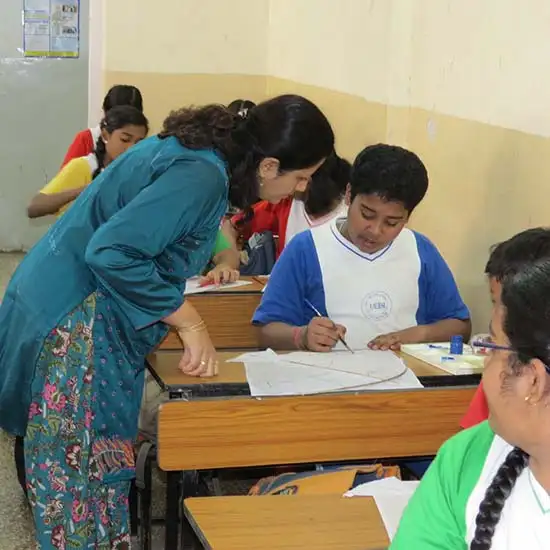 art educator Chitra Vaidya explaining to boy at Kite Painting Workshop