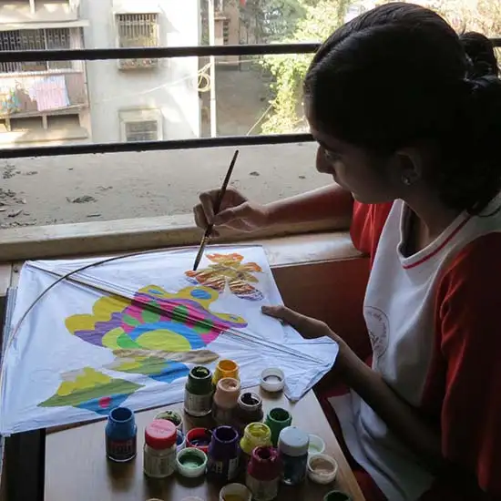 Girl of Madhavrao Bhagwat High School painting a kite