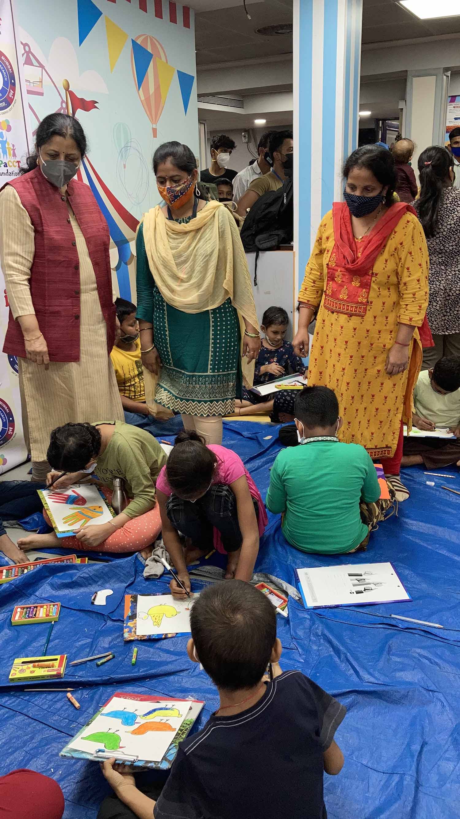 Chitra Vaidya, Priti Naik looking at chidren at Khula Aasmaan art workshop