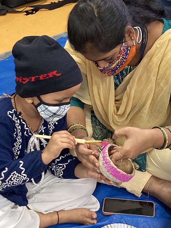 Little boy doing object painting with his mother at the art workshop by Khula Aasmaan at Tata Memorial Centre, Mumbai